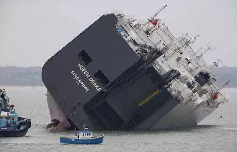 The cargo ship Hoegh Osaka lies on its side